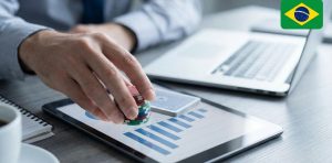 A gambler with chips on hand on top of a tablet showing online portfolio of casino games